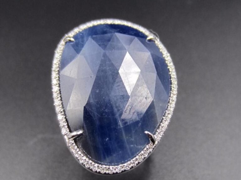 BAGUE en or gris (750 millièmes) serti d’un saphir facetté entouré de diamants taille brillan