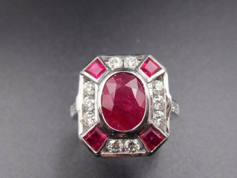 BAGUE en or gris (750 millièmes) serti d’une émeraude de forme ovale pesant 3 carats, épaulée de six diamants taille brillan