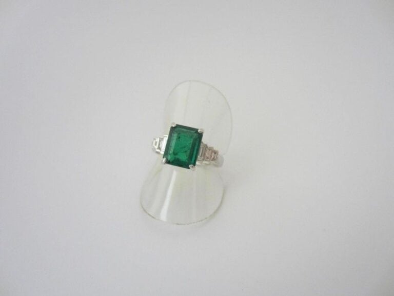 BAGUE en or gris (750 millièmes) serti d?une émeraude rectangulaire épaulé de diamants baguettes, en chut