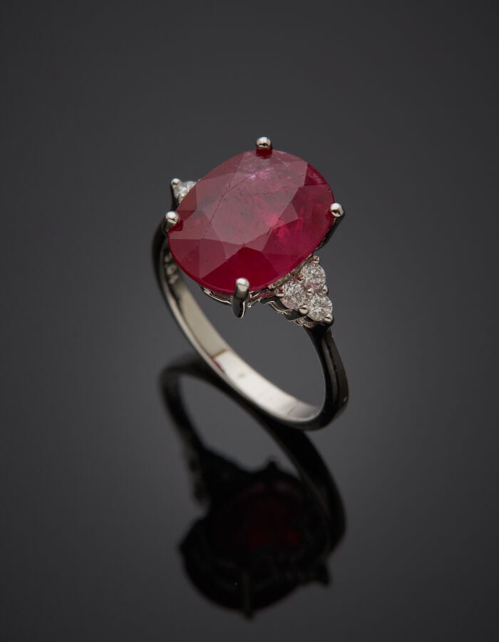 BAGUE en or gris (750‰) serti d'un rubis de forme ovale, épaulé de trois diaman…