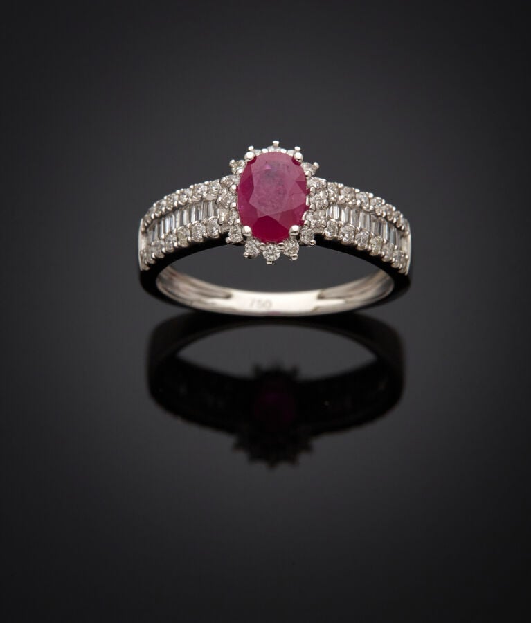 BAGUE en or gris (750‰) serti d'un rubis ovale, entouré et épaulé de diamants t…