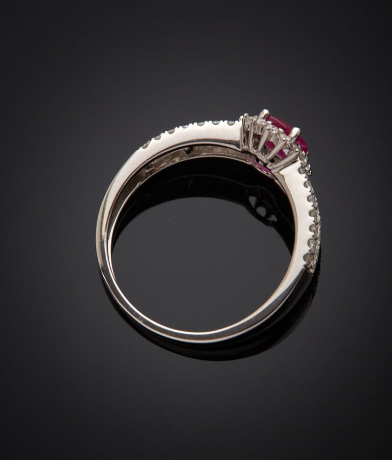 BAGUE en or gris (750‰) serti d'un rubis ovale, entouré et épaulé de diamants t…