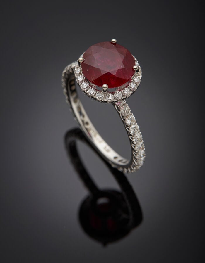 BAGUE en or gris (750‰) serti d'un rubis rond pesant 3,06 carats, entouré de di…