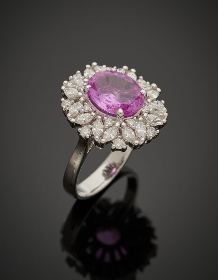 BAGUE en or gris (750‰) serti d'un saphir rose ovale pesant 3,17 carats, entour…