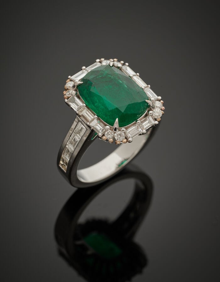 BAGUE en or gris (750‰) serti d'une émeraude de forme coussin, entourée de diam…