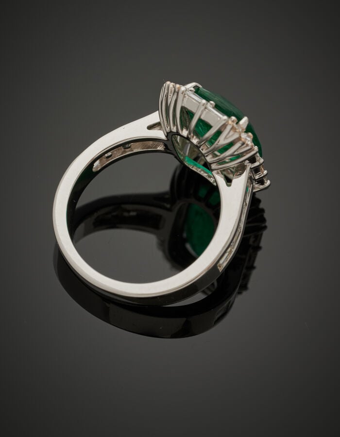 BAGUE en or gris (750‰) serti d'une émeraude de forme coussin, entourée de diam…