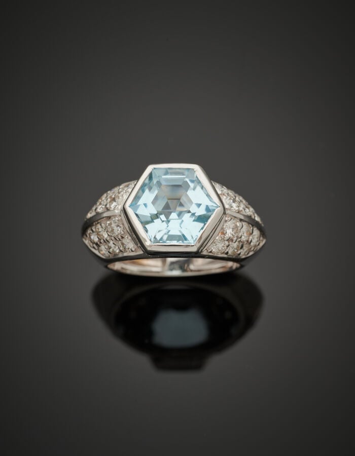 BAGUE en or gris (750‰) serti d'une topaze hexagonale, épaulée de pavages de di…