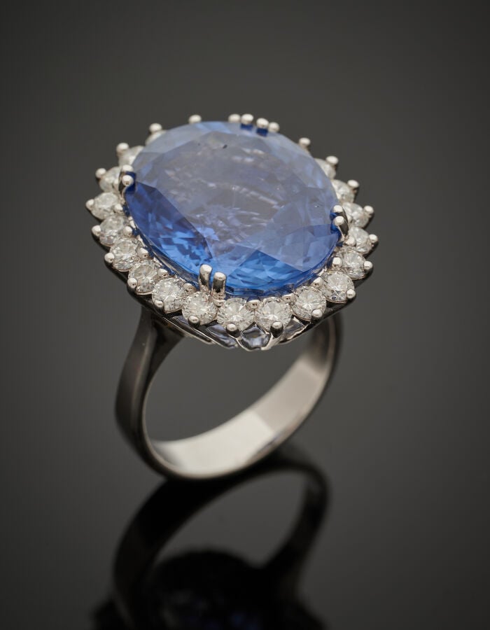 BAGUE en or gris (750‰) serti de saphir pesant 20,01 carats, entouré de 22 diam…