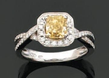 BAGUE en or gris ajouré serti d'un diamant «Fancy Yellow», de forme coussin entouré et épaulé d'alignements de diamants taille brillan
