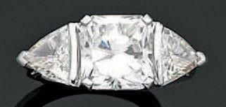 BAGUE en or gris serti d'un diamant taille radiant pesant 4 carats épaulé de deux diamants troïdia