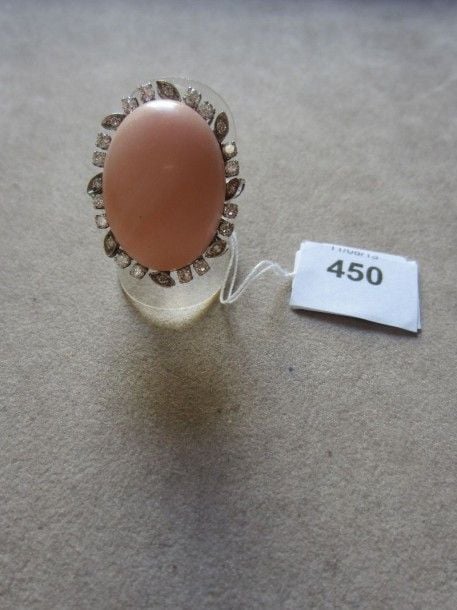 BAGUE en or gris serti d'un important cabochon de corail peau d'ange entouré de diamants taille brillant et 8/