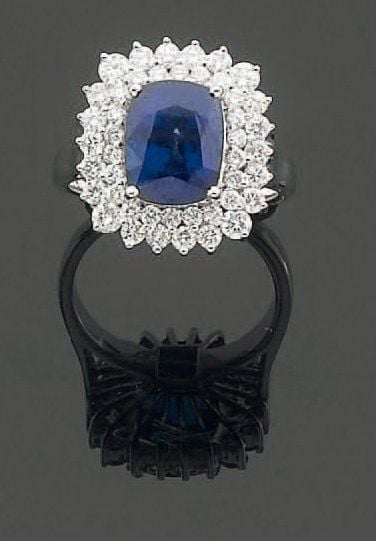 BAGUE en or gris serti d'un saphir de forme coussin entouré d'un double alignement de diamants taille brillan