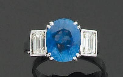 BAGUE en or gris serti d'un saphir ovale épaulé de deux diamants taillés à degré