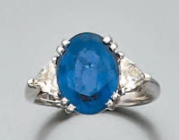 BAGUE en or gris serti d'un saphir ovale épaulé de deux diamants triangle