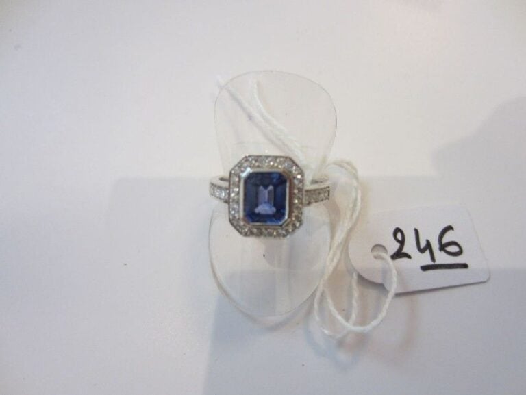 BAGUE en or gris serti d'un saphir taillé à degrés entouré et épaulé de diamants taille brillan