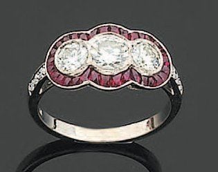 BAGUE en or gris serti de trois diamants de taille brillant soulignés de rubis calibrés et facetté
