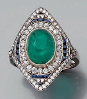 BAGUE en or gris serti en son centre d'une émeraude cabochon entourée de diamants et de saphirs calibré