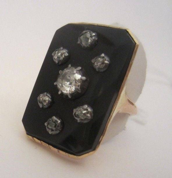 Bague en or jaune (585 millièmes)et argent, serti d'une plaque rectangulaire d'onyx sertie de 7 diamants taille brillant dont un au centre plus importan