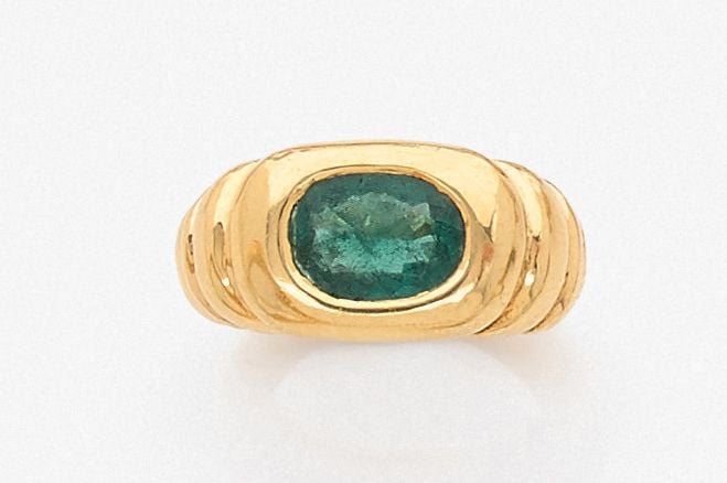•BAGUE en or jaune (750‰) godronné serti d'une émeraude de forme coussi