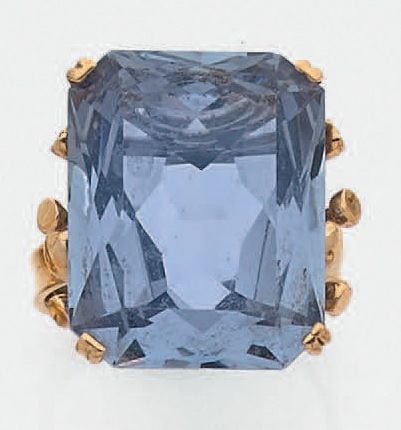 BAGUE en or jaune (750 millièmes) ajouré et boulé, serti d'une importante pierre bleue d'imitation de forme rectangulaire (égrisures