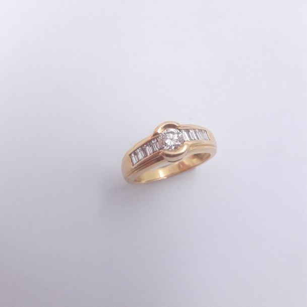 BAGUE en or jaune (750 millièmes) centré d'un diamant taille brillant épaulé de huit diamants taille baguett