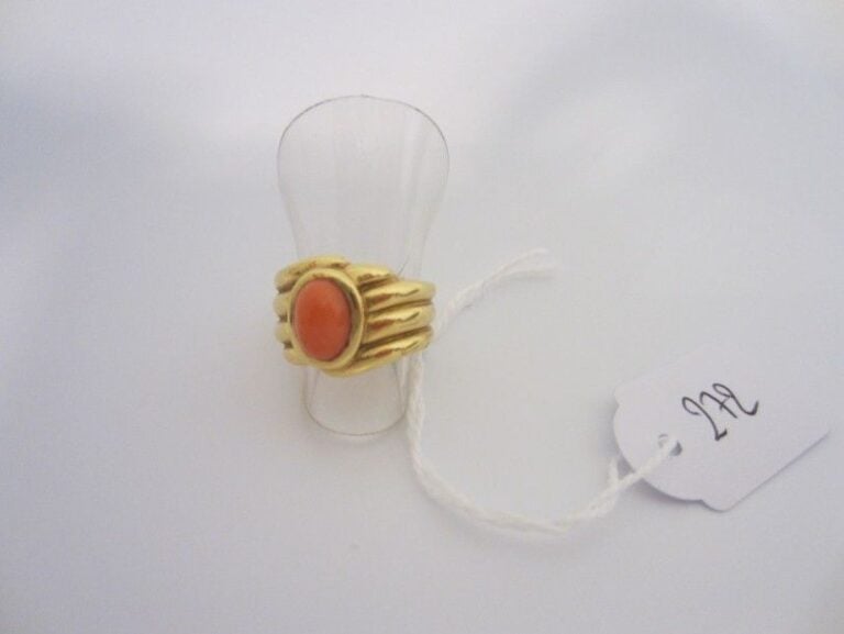 BAGUE en or jaune (750 millièmes) godronnée serti d'un cabochon de corail de forme oval