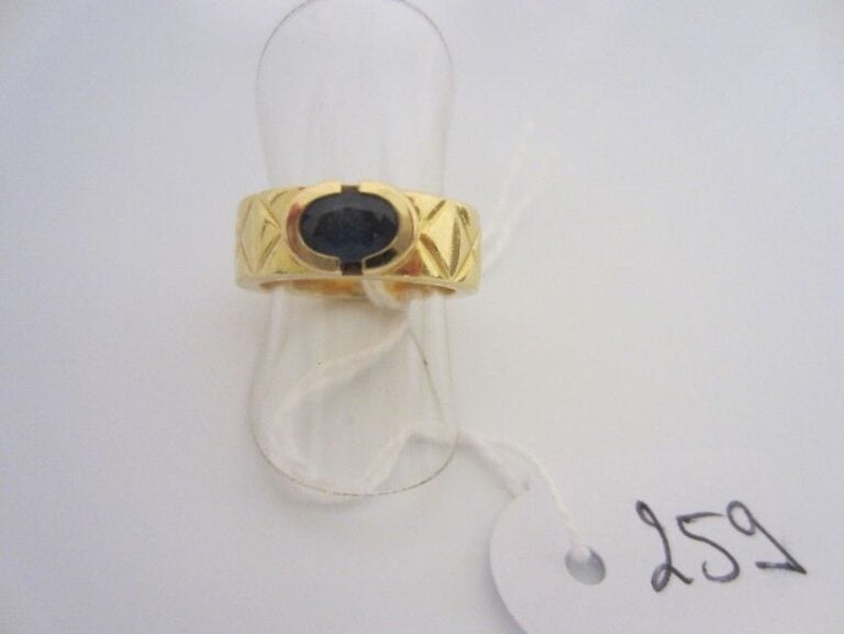 BAGUE en or jaune (750 millièmes) matelassé serti d'un saphir oval