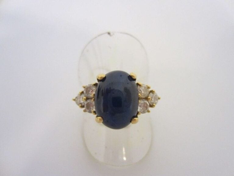 BAGUE en or jaune (750 millièmes), ornée d'un saphir cabochon, épaulé de 6 diamants taille brillan