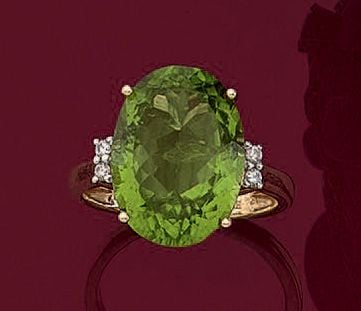 BAGUE en or jaune (750 millièmes) serti d'un péridot de forme ovale, épaulé de quatre diamants taille brillan