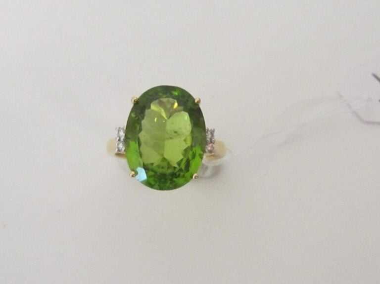 BAGUE en or jaune (750 millièmes) serti d'un péridot de forme ovale, épaulé de quatre diamants taille brillan