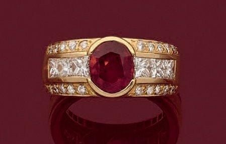 BAGUE en or jaune (750 millièmes) serti d'un rubis de forme ovale épaulé de diamants taille princesse et brillan