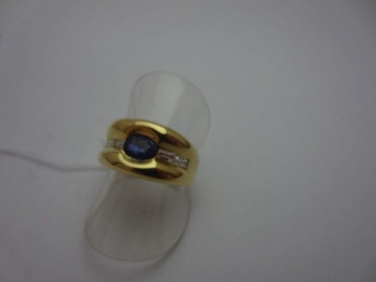BAGUE en or jaune (750 millièmes) serti d'un saphir de forme ovale épaulé de quatre diamants baguette