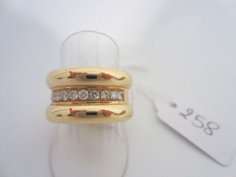 BAGUE en or jaune (750 millièmes) serti d'une ligne de diamants taille brillant épaulé de deux godron