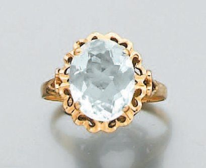 BAGUE en or jaune ajouré à motifs de petits coeurs, serti d'une aigue-marine de forme oval