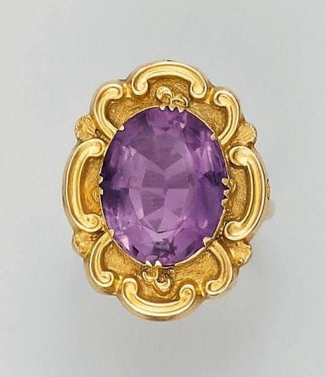 BAGUE en or jaune ciselé et amati, à décor d'accolades, serti d'une importante améthyste de forme oval
