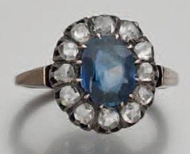 BAGUE en or jaune et argent serti d'une pierre bleue de forme ovale entouré de diamants taillés en ros
