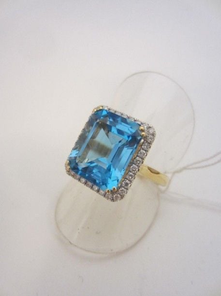 BAGUE en or jaune et or gris (750 millièmes) serti d’une topaze de forme rectangulaire taillé à degrés entourée de petits diamants