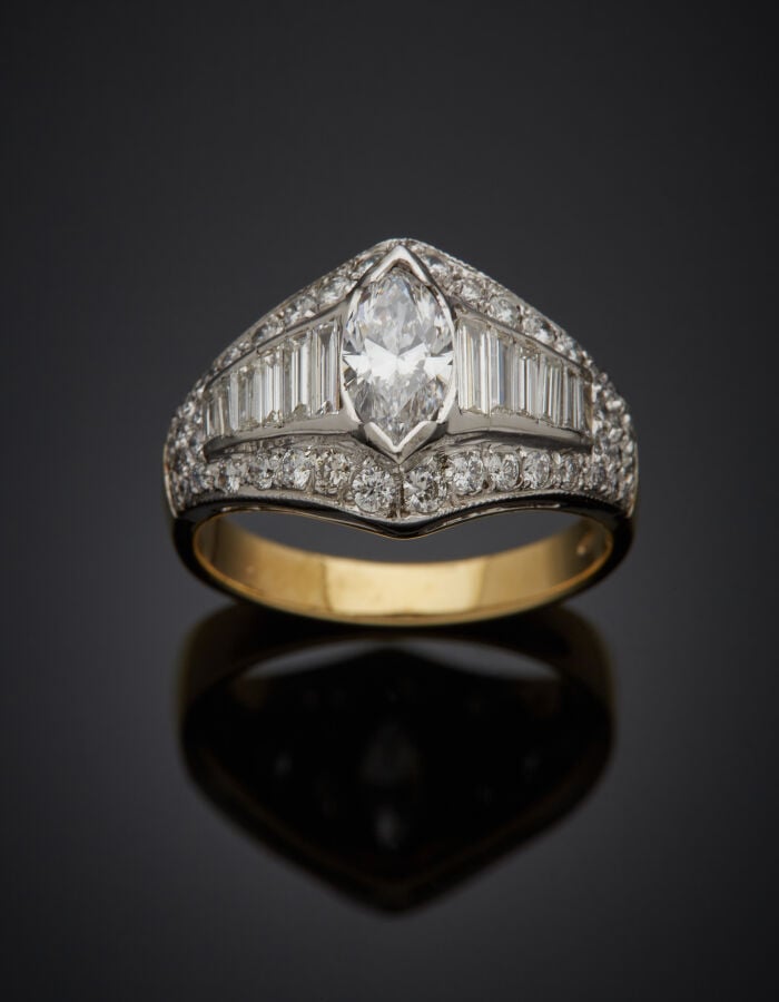 BAGUE en or jaune et or gris (750‰) serti d'un diamant taille navette épaulé de…