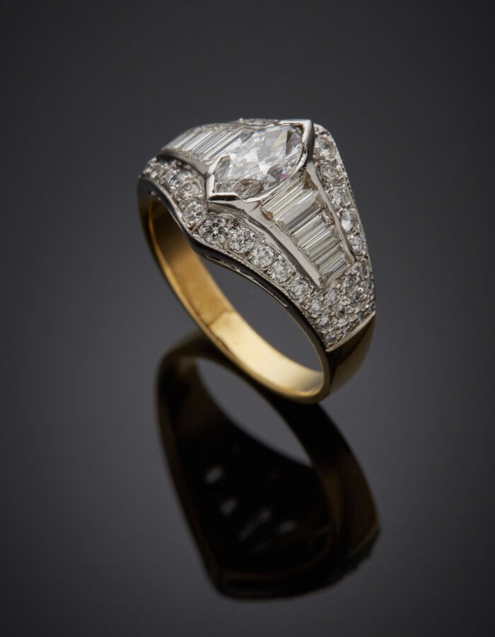 BAGUE en or jaune et or gris (750‰) serti d'un diamant taille navette épaulé de…