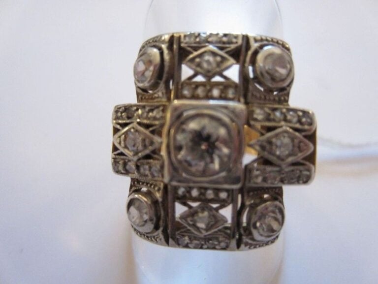 BAGUE en or jaune et or gris ajouré à motifs géométriques serti de diamants taille ancienne et taillés en rose dont un, au centre, plus importan