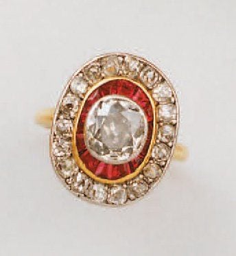 Bague en or jaune et platine sertie d'un diamant ovale de taille ancienne, dans un double entourage de rubis calibrés et diamants de taille ancienn