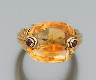 BAGUE en or jaune serti d'une citrine ovale entièrement facettée et deux rubis cabochon