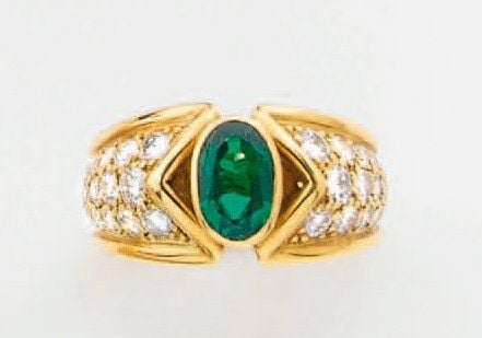 BAGUE en or jaune serti d'une émeraude ovale épaulée de pavages de diamants taille brillan