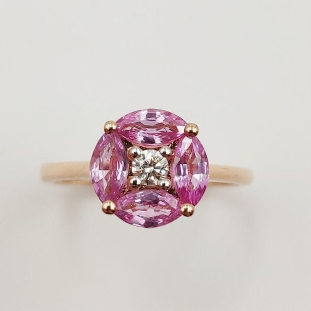 •BAGUE en or rose (750‰) centré d'un diamant taille brillant, entouré de quatre saphirs roses taille navett