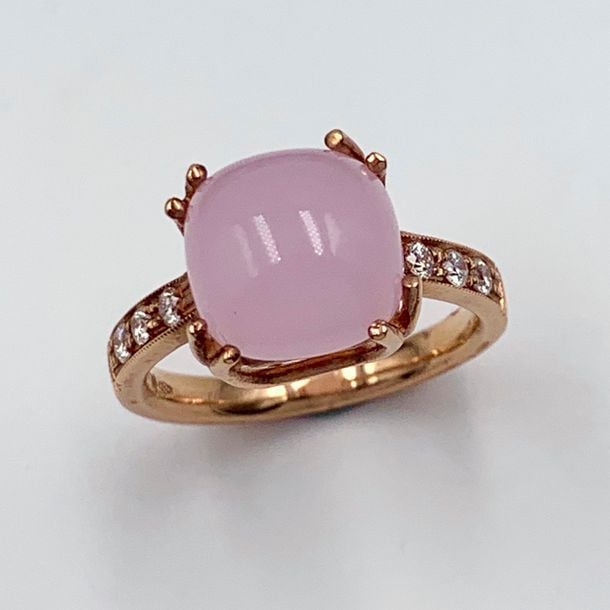 BAGUE en or rose (750 millièmes) serti d'un quartz rose cabochon, épaulée de six diamants taille brillan