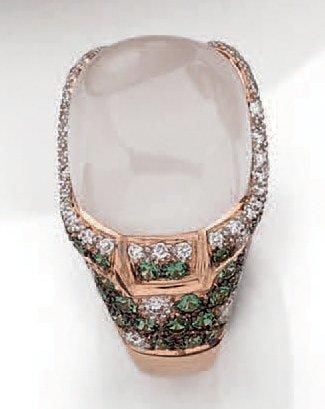 BAGUE en or rose (750 millièmes) serti d'une calcédoine blanche cabochon de forme coussin entourée de pavages de diamants et grenats vert
