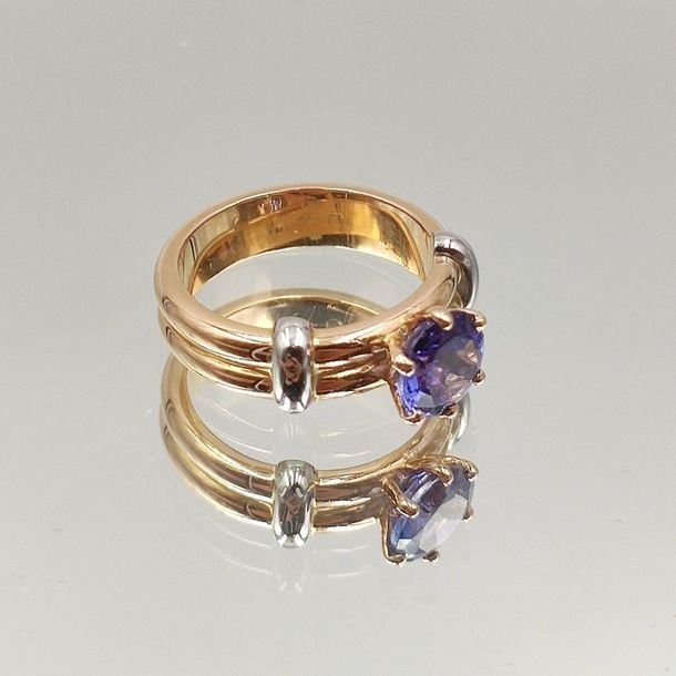 •BAGUE en or rose et or gris (750‰) double jonc, serti d'une tanzanite rond