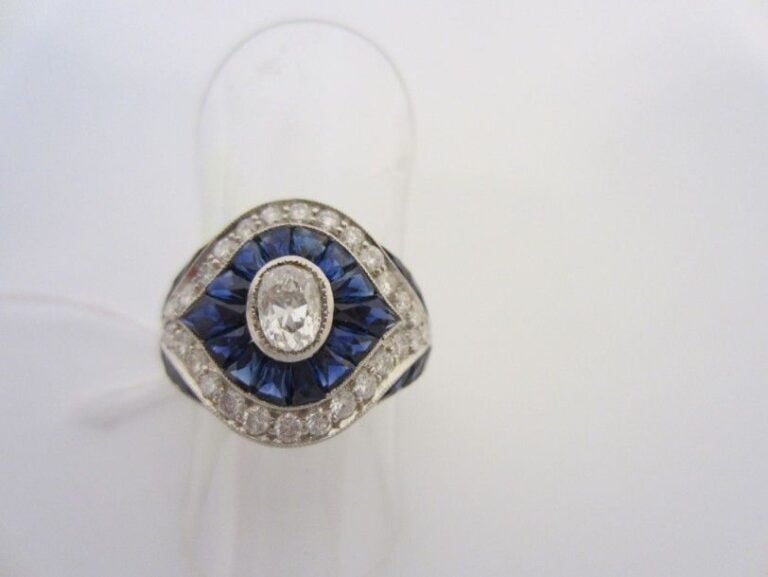 BAGUE en platine (900 millièmes) serti au centre d?un diamant taille ancienne de forme ovale entouré de saphirs calibrés et diamants taille brillan