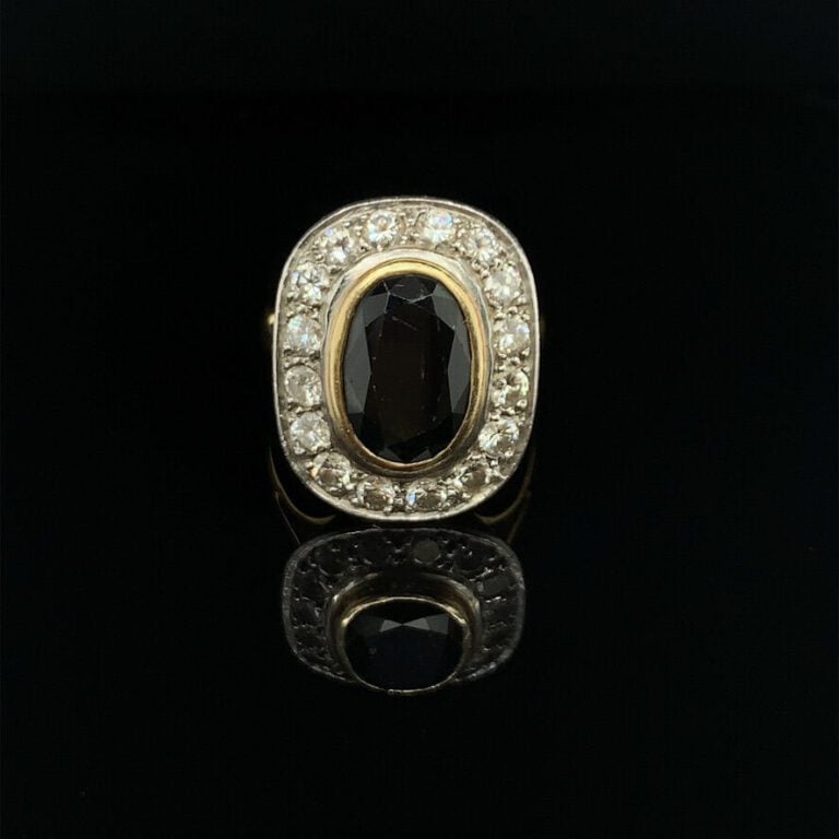 BAGUE en platine (950‰) et or jaune (750‰) serti d'un saphir ovale entouré de d…