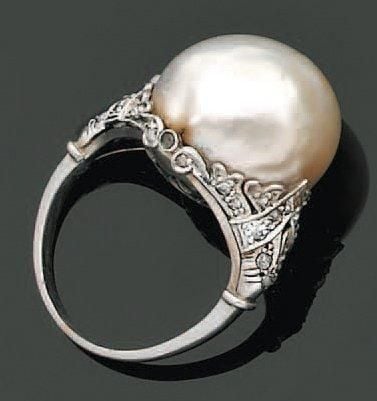BAGUE en platine ajouré et ciselé serti d'une importante perle de culture blanche et de diamants taillés en ros